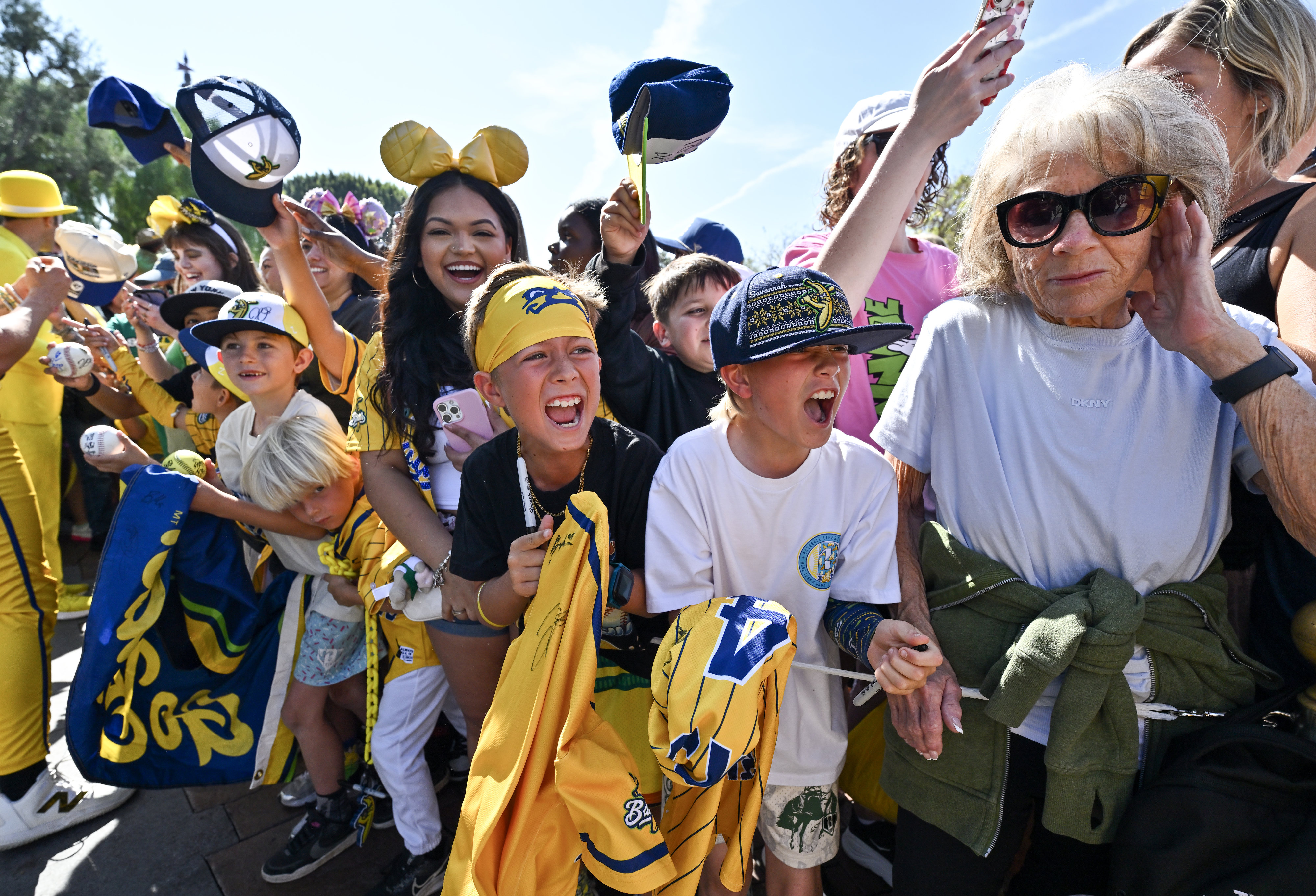 Mason Evans, 8, center with bandana, joins other fans as...