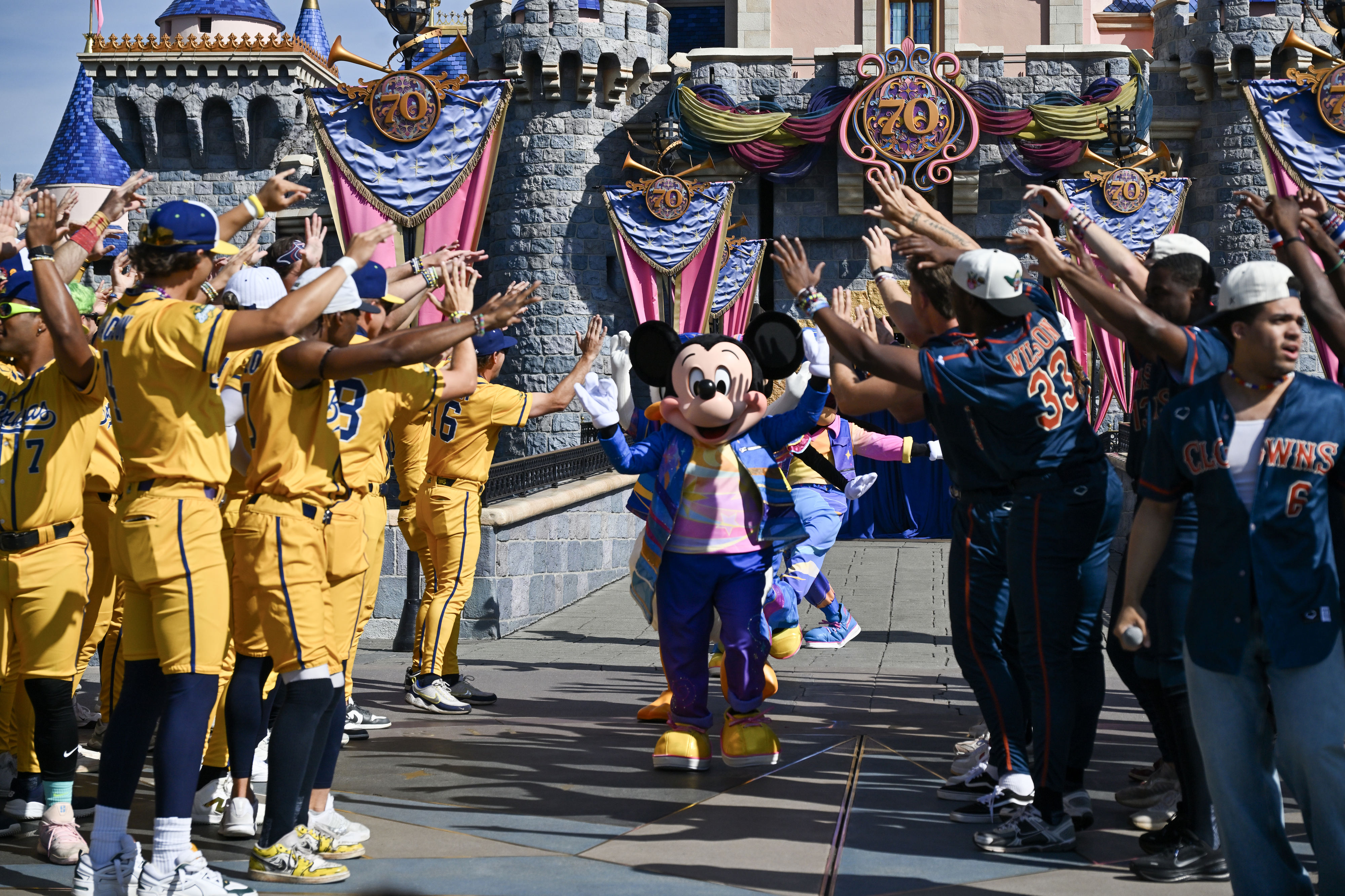 Mickey Mouse greets the Savannah Bananas and Indianapolis Clowns in...