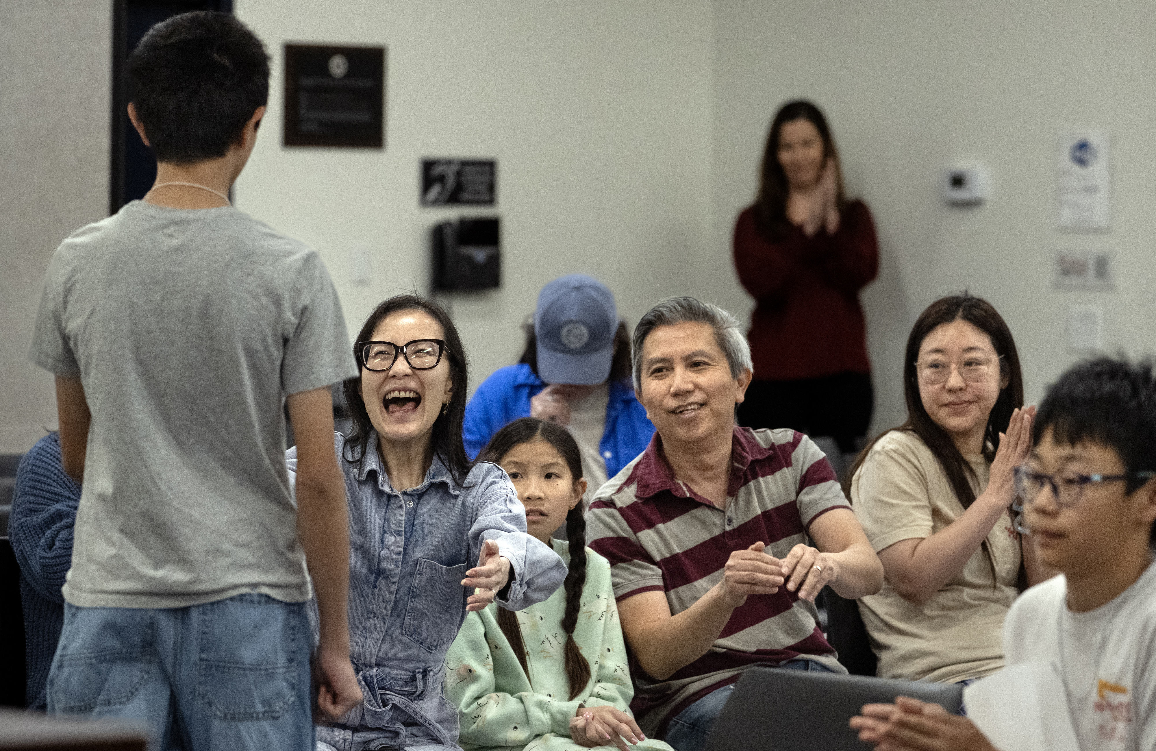 Katie Chan congratulates her son, Riley, 13, after he made...