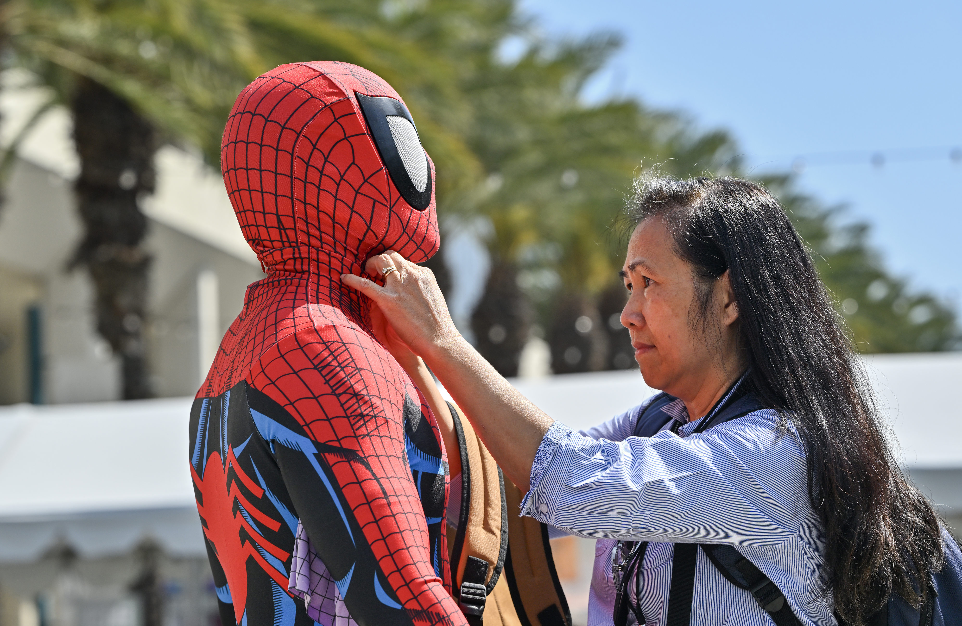 Mindy Lee helps her son, Andrew Tse, with his Spider-Man...