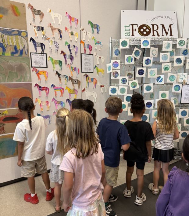 Crown Point Junior Music Academy students looking at artwork for the "The Year of the Horse" theme, left, and "Earth Is In Your Hands" theme. (Erin Pennell)