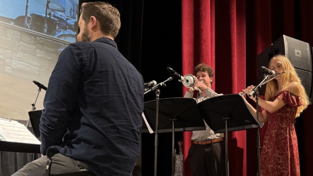Mission Bay High School Music Director JP Balmat conducting the ensemble, including trumpeter Elias Nupsl and flutist Alyssa Deaton. (Cyril A. Reinicke)