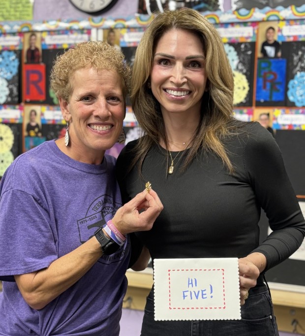 Tracy Roth with Rancho Bernardo resident Erika Fellars, who donated to Roth's fundraiser in memory of her late husband, Todd Fellars. Roth is holding his Navy insignia, which she wore during all seven marathons in the challenge. (Courtesy of Tracy Roth)