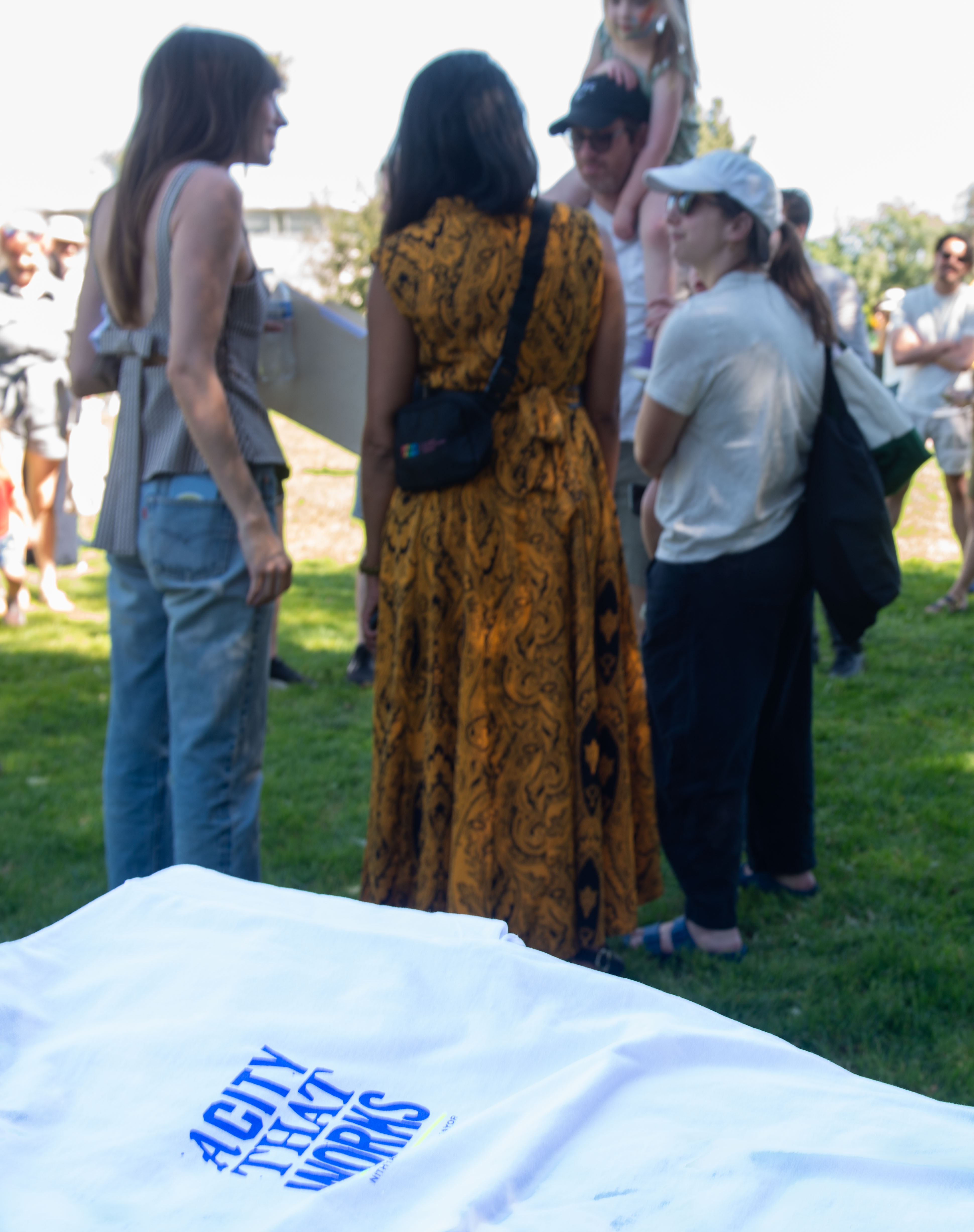 City Councilwoman Nithya Raman, in yellow, speaks with attendees of...