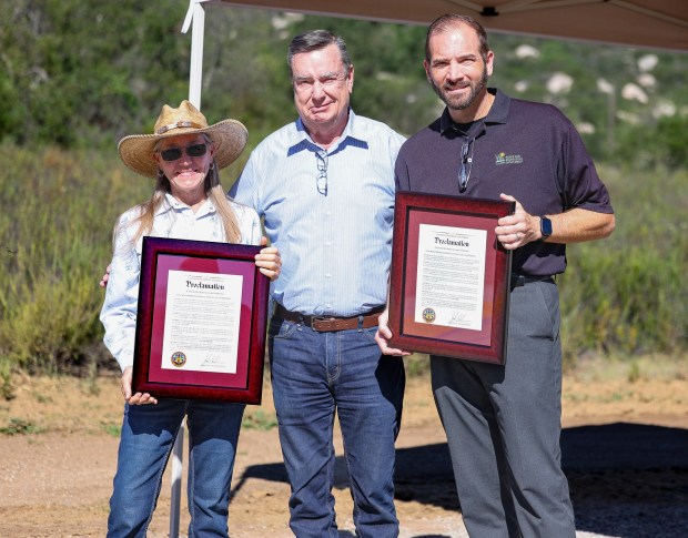 Ramona Trails Association President Cheryl Wegner, left, and San Diego County Parks and Recreation Director Jason Hemmens receive proclamations from District 2 San Diego County Supervisor Joel Anderson, center, in recognition of their dedication to the Mount Woodson Gateway County Preserve parking lot project. (Stephanie Rene Ogilvie)