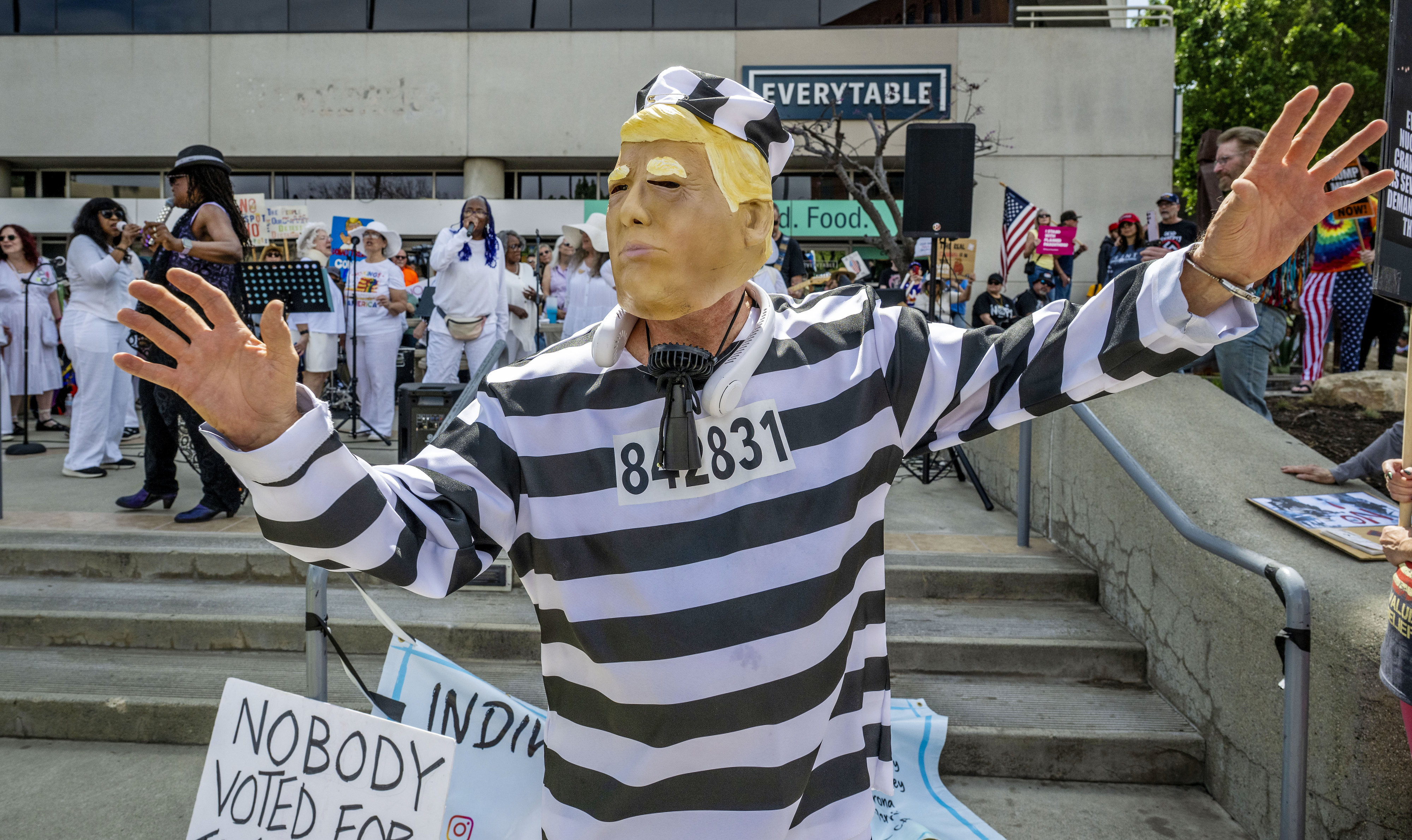 A man dressed as Trump and a prisoner dances as...