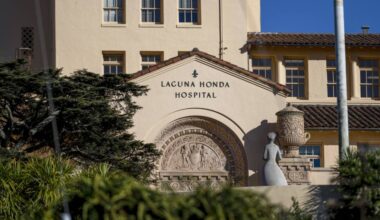 Signage reading Laguna Honda Hospital over the entryway to a large tile-roofed building.