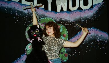 a woman fixes bead art to a street pole