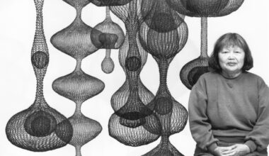 woman next to globular mesh hanging sculptures