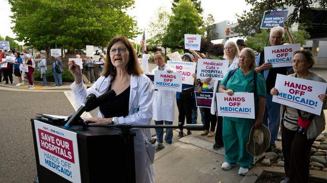 Dr. Kimberly Buss speaks at a “Save Our Hospitals” rally last year ahead of the passage of the Republican megabill that included cuts to Medicaid. Backers of a proposed Billionaire tax say it will help blunt the severity of the bill’s affects on California health care. 
