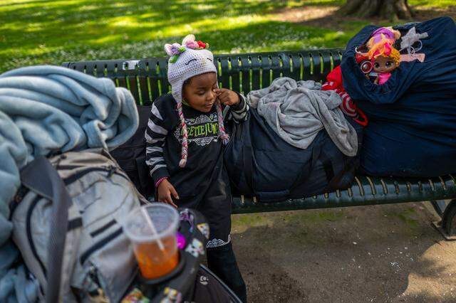 Makhìla Williams, 4, rests on a bench in James Marshall Park near a bag full of her toys that her homeless parents, Tanika and Michael Williams, lug around as they continue their search for housing in midtown Sacramento on March 9. A blanket rests on a stroller that will later serve as a bed for her to nap and sleep. 