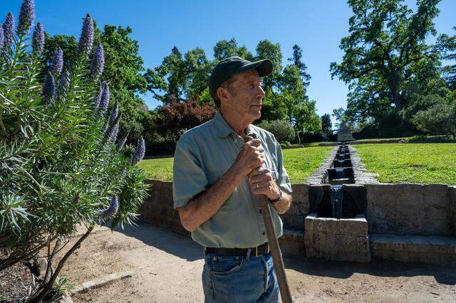 Dale Claypoole, 82, a member of the Land Park Volunteer Corps, rests against a shovel on March 17 as he stands near the Charles Swanston statue — an area in William Land Park that the zoo would like to annex. Claypoole’s wife, a master gardener, helped select flowers planted near the statue by the volunteer corps.