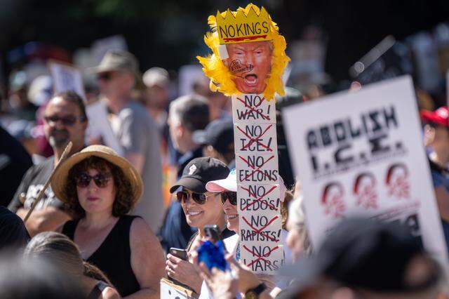 Protesters hold signs during the "No Kings" rally at the state capitol in Sacramento on Saturday, March 28, 2026.