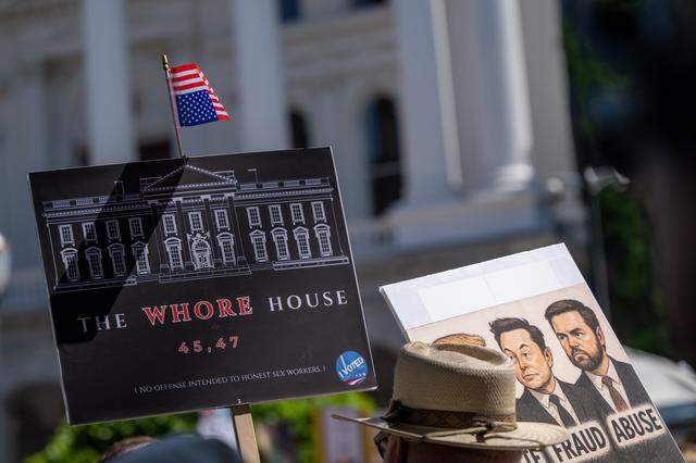 Protesters hold signs during a "No Kings" rally at the state Capitol in Sacramento on Saturday.