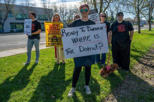 Cass Hammer, a third-grade teacher on the Natomas teacher union's bargaining team, holds a sign Monday outside Natomas Unified School District headquarters, where leaders held a press conference, in Sacramento.