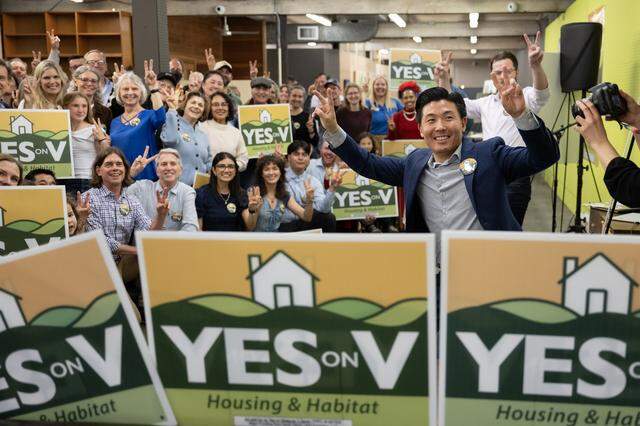 Campaign director Andrew Kim, right, and supporters of Yes on Measure V, flash victory signs at the kick-off rally in Davis on Wednesday. The measure would allow a 498-acre development with 1,800 homes on the city's northern boundary to move forward.