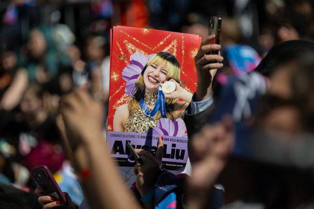 A member of a crowd of thousands holds a picture of Olympic gold medalist Alysa Liu during a celebration in her honor at Frank Ogawa Plaza in Oakland on Thursday.