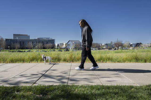 Shana McDaniels, a River District tenant, walks her dog Winter on Wednesday.