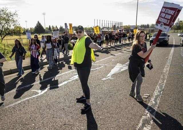 Natomas High School students are helped across Truxel Road as they walk out to join a teachers strike on Monday.