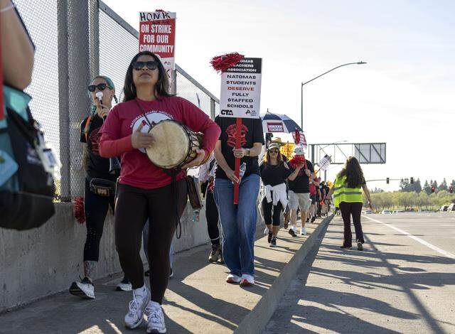 Lupe Heredia, a school social worker at Natomas Unified School District, walks along Truxel Road in Sacramento during a Natomas High School student walkout in support of teachers on Monday.