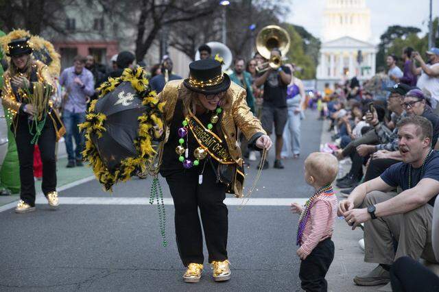 The NOLACal Second Liners pass out beads during the City of Trees Parade in Sacramento on Saturday, Feb. 28.