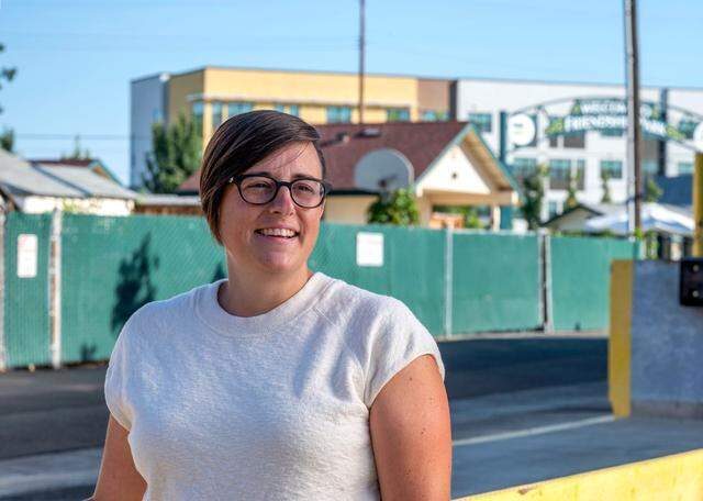 Angela Hassell, executive director of homeless services provider Loaves & Fishes, stands on the grounds of her organization near Friendship Park in Sacramento’s River District in 2022 as the then-new Mirasol Village housing complex rises in the distance.