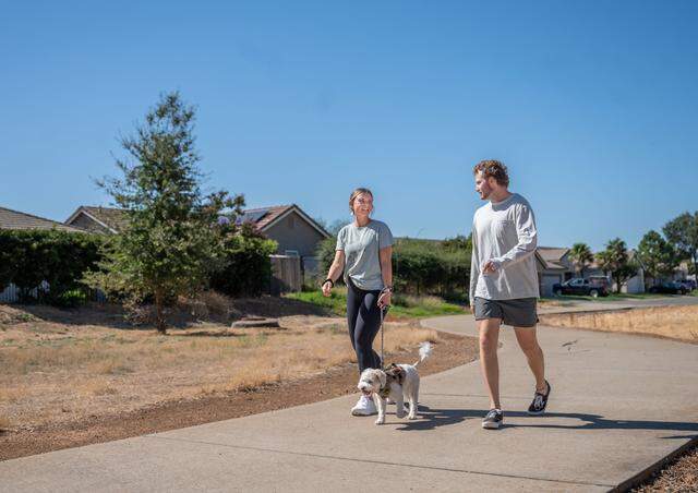 Olivia and Tanner  Keller walk their dog Rory near their home in Lincoln on Tuesday, Oct. 3, 2023. 