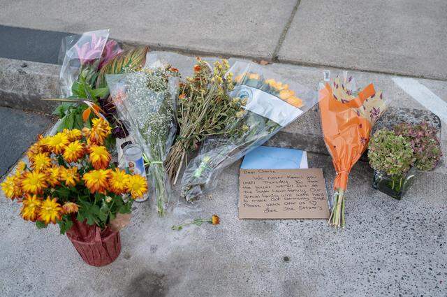 Flowers and handwritten cards rest the alley near the Sutter Lawn Tennis Club in East Sacramento on Monday, Oct. 24, 2022, close to the location of the fatal shooting of Charles Starzynski, before a private community meeting at the club about the incident.