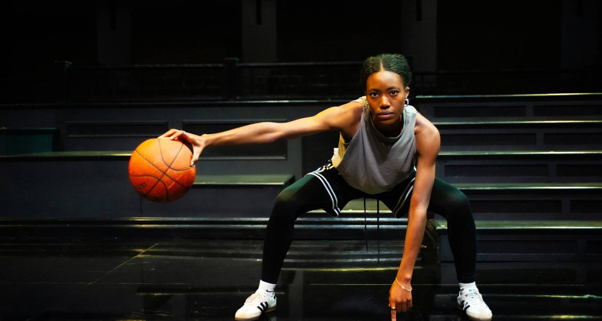 A young woman palms a basketball.