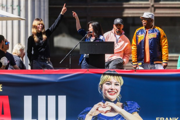 Olympic figure skater Kristi Yamaguchi, center, speaks about Olympic gold medalist figure skater Alysa Liu, left, as Oakland's undefeated world champion boxer and 2004 Olympic gold medalist Andre Ward, right center, and Oakland-born radio and television host Sway Calloway look on during Liu's celebration rally at Frank Ogawa Plaza in Oakland, Calif., on Thursday, March 12, 2026. Liu became the first American woman in 24 years to win Olympic gold in figure skating. (Ray Chavez/Bay Area News Group)