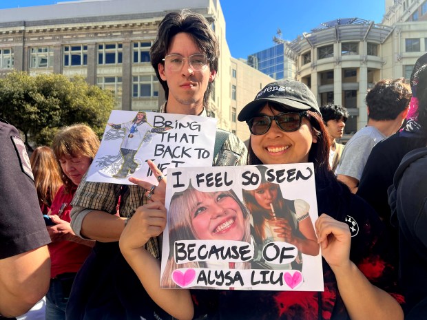 Tyler McMahon and his friend Alison Ramirez of San Francisco hold up collages in honor of Alysa Liu before the start of Alicia Liu's celebration rally at Frank Ogawa Plaza in Oakland, Calif., on Thursday, March 12, 2026. (Ray Chavez/Bay Area News Group)