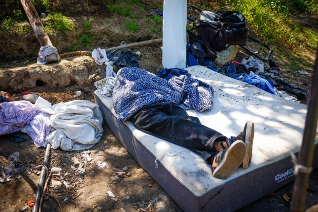 A person sleeps on an open mattress at the Jungle in San Jose Calif., on Saturday, March 14, 2026. (Shae Hammond/Bay Area News Group)