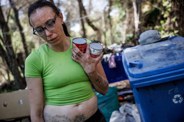 Jasmin B., a resident of "The Jungle," holds cans of pork and beans as she talks about living in the homeless encampment on March 18, 2026, in San Jose, Calif. (Dai Sugano/Bay Area News Group)