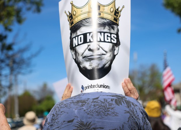 A person carries a sign during a No Kings protest in downtown San Jose, Calif., on Saturday, March 28, 2026. (Shae Hammond/Bay Area News Group)