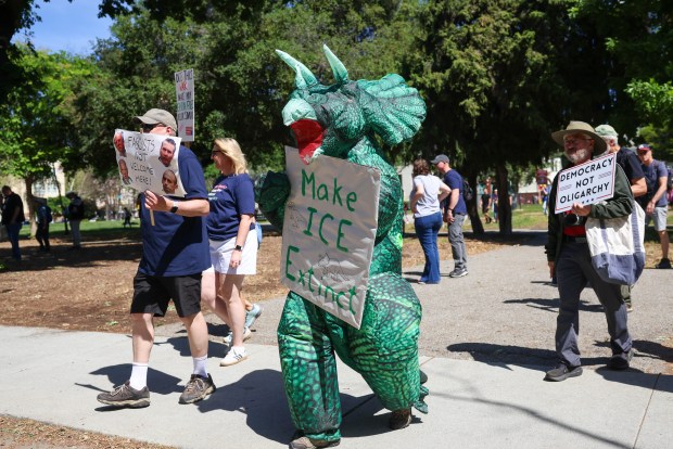 A person in a dinosaur costume carries a sign that says "Make ICE extinct" during a No Kings protest in downtown San Jose, Calif., on Saturday, March 28, 2026. (Shae Hammond/Bay Area News Group)