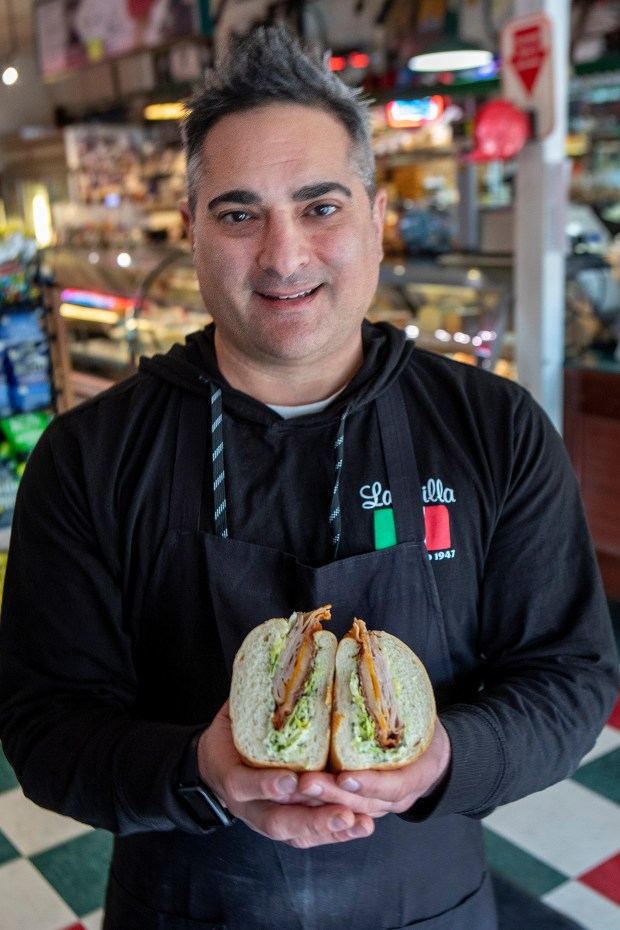 Chris Bertucelli shows off his Chris Combo sandwich, Tuesday, Feb. 21, 2023, at La Villa Delicatessen in San Jose, Calif. The sandwich, made from ingredients Bertucelli refuses to disclose, is a big hit with members of the Sharks and 49er organizations. (Karl Mondon/Bay Area News Group)