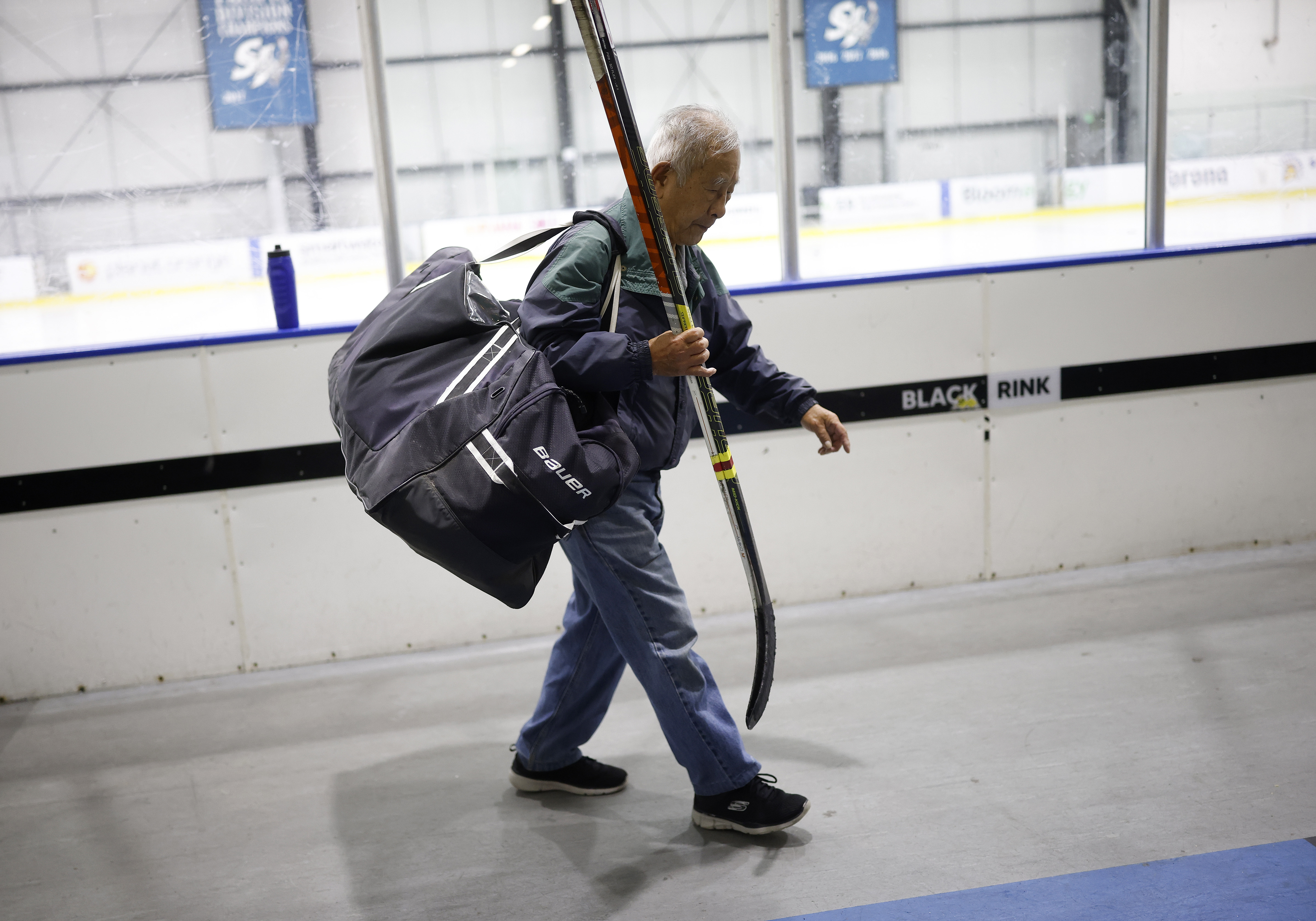 Ed Asato (3), 87, from Sunnyvale, carries his equipment out...