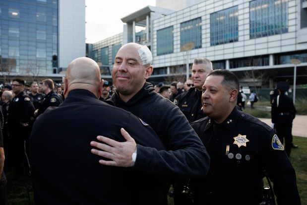 San Jose police sergeant Gerardo Silva, center, who has been with the department for 13 years, was released from the hospital to a crowd of supporting fellow officers at Santa Clara Valley Medical Center on Thursday, Jan. 22, 2026. The sergeant suffered a gunshot wound to his head during a shootout with a man suspected in a robbery and carjacking spree over the past week.(Dai Sugano/ Bay Area News Group)