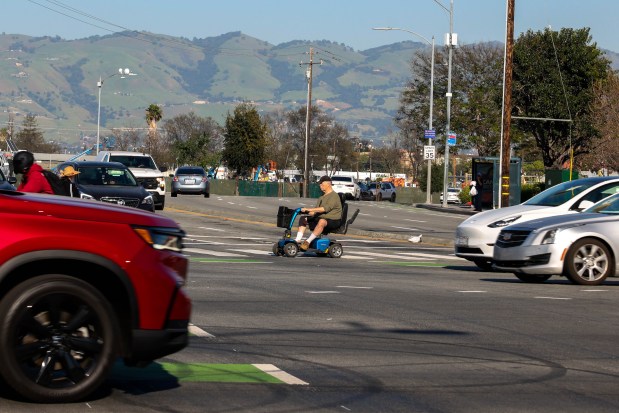 A senior using a power wheelchair crosses the wide intersection of Monterey Road and Curtner Avenue in San Jose, Calif., on Wednesday, March 18, 2026. (Ray Chavez/Bay Area News Group)