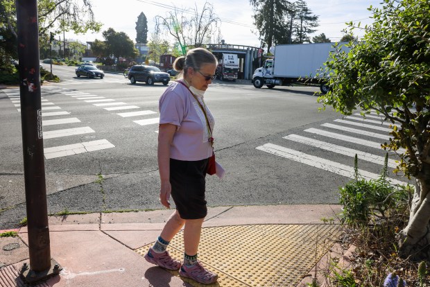 Melissa Quilter, 66, looks at the wide intersection of The Alameda and Marin Avenue in Berkeley, Calif., on Friday, March 13, 2026. "I don't cross this intersection any longer because the cars don't stop when the pedestrians have the right-of-way," Quilter said. "I would love to see lights that control the left turns and speed limits to be enforced." (Ray Chavez/Bay Area News Group)