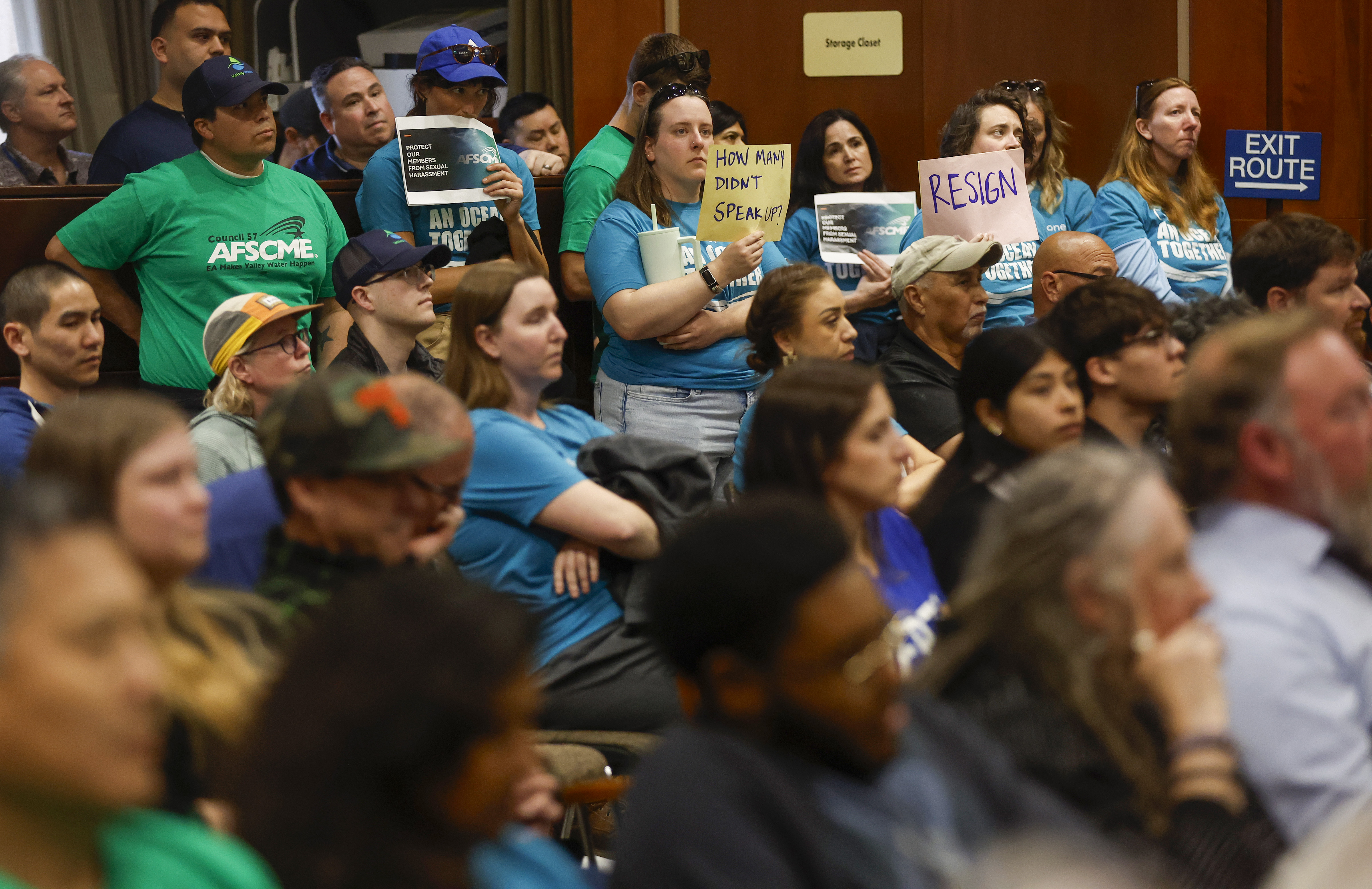 More than 150 employees and their supporters stand in a...