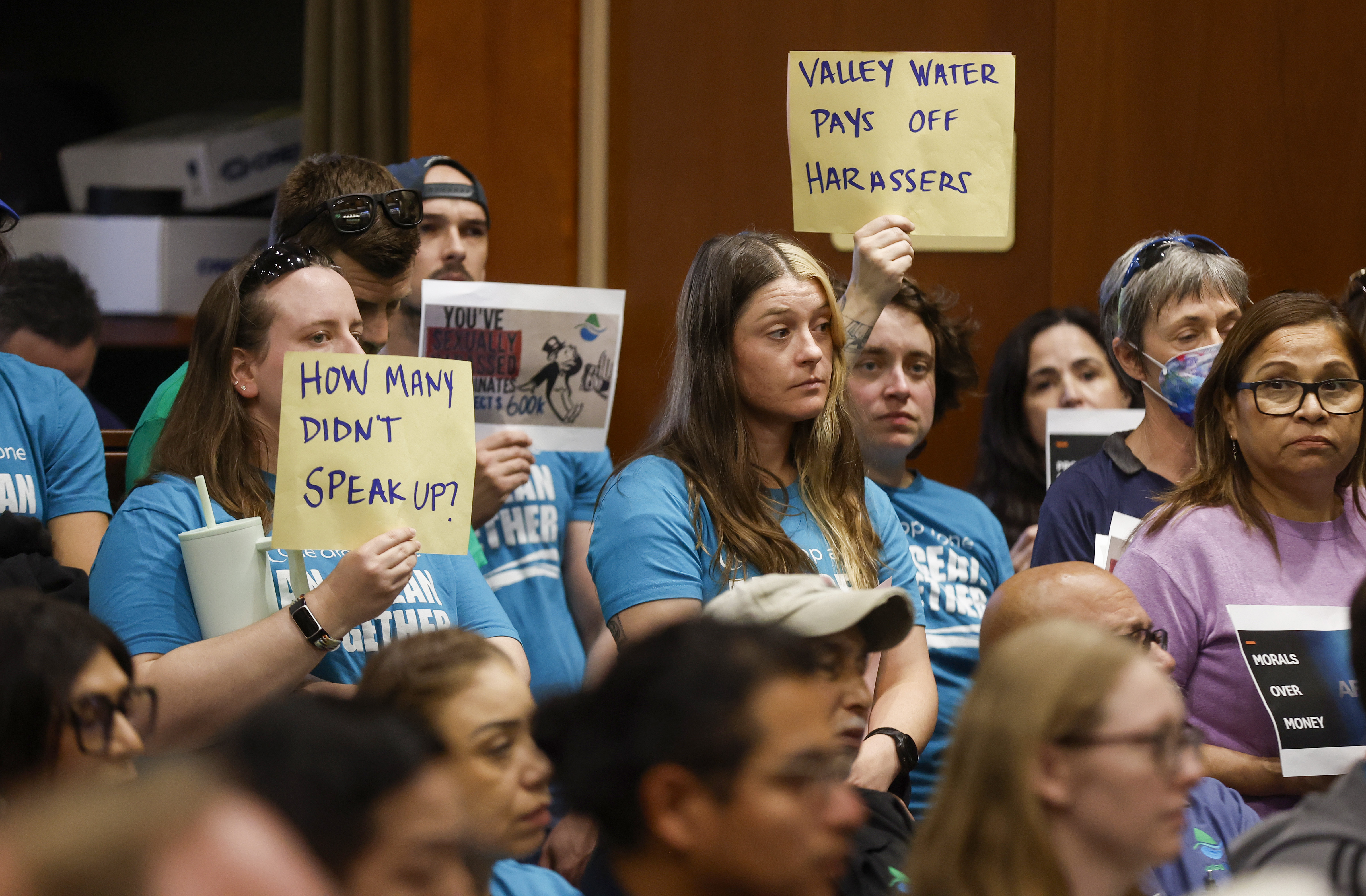 More than 150 employees and their supporters stand in a...