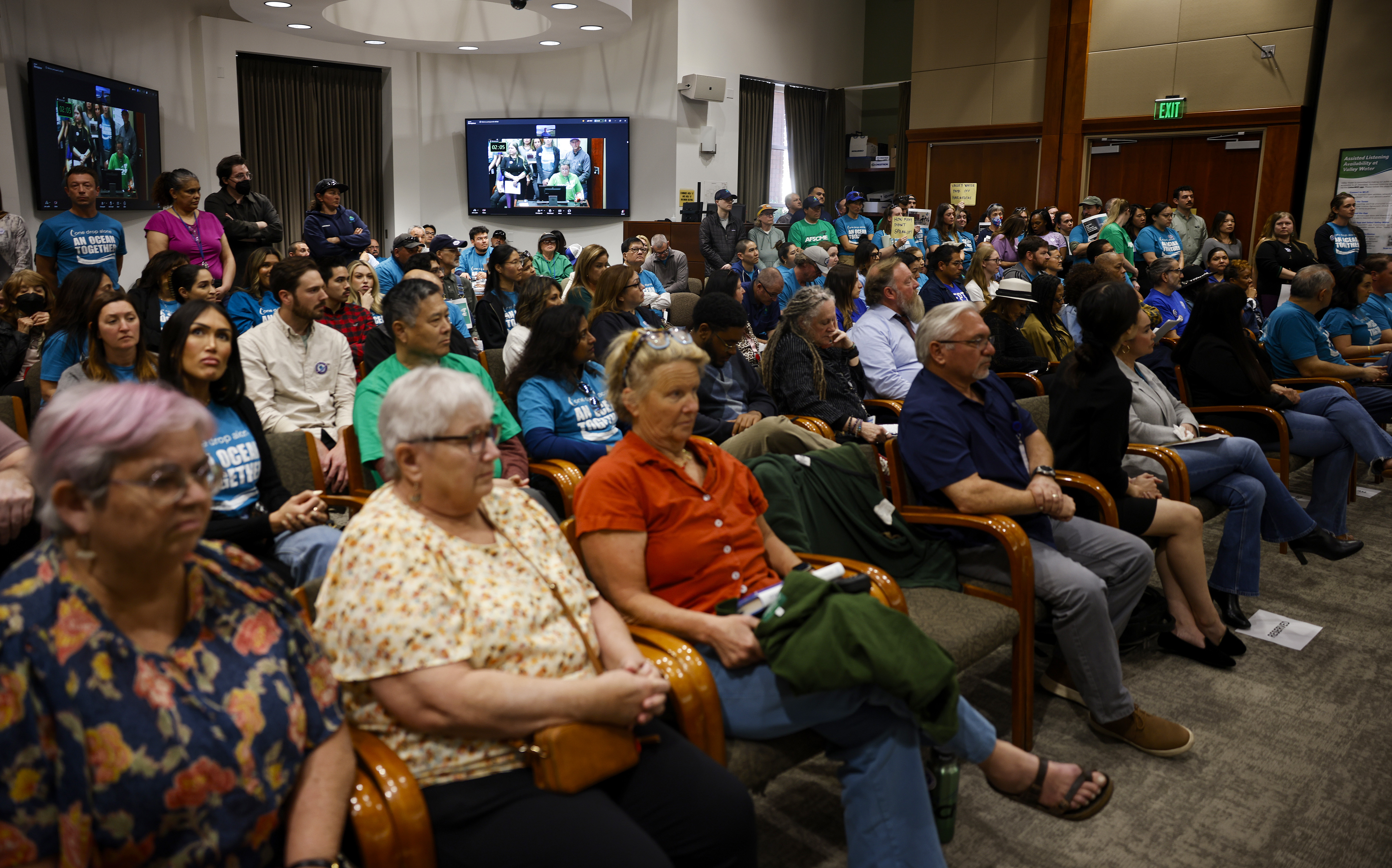 More than 150 employees and their supporters stand in a...