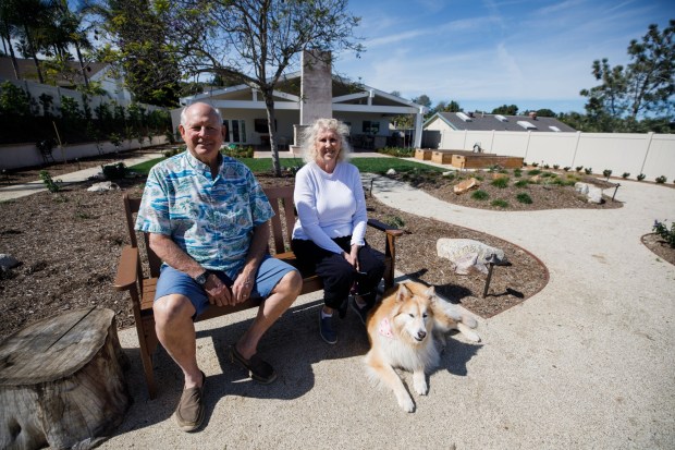 Steve and Beth Elliott, with their 4-year-old dog, Roxy, have play space for the canine and an area for gardening and entertaining. (Kristian Carreon / The San Diego Union-Tribune)