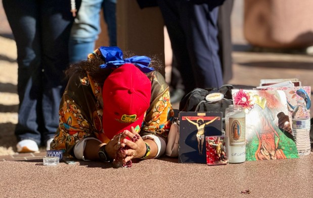 A parishioner prays outside the Edward J. Schwartz Federal Building in San Diego on March 3, 2026, in support of a community member who had an immigration hearing. (Alexandra Mendoza/The San Diego Union-Tribune)
