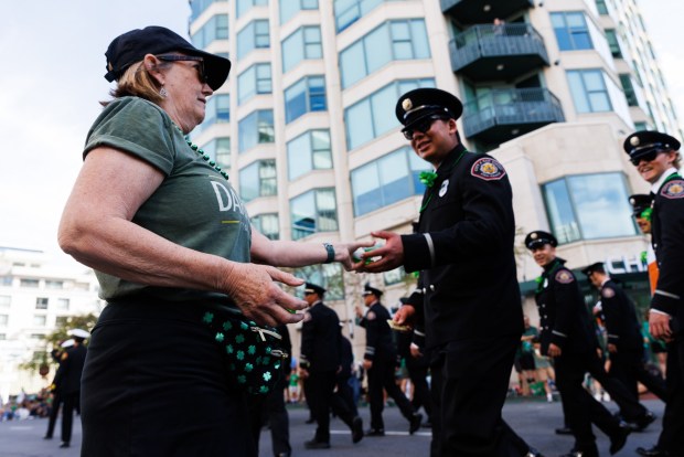 Maureen Knox, 63, hands out gelatin shots during the 44th Annual St. Patrick's Day Parade and Festival in San Diego on Saturday, March 14, 2026. (Kristian Carreon / The San Diego Union-Tribune)
