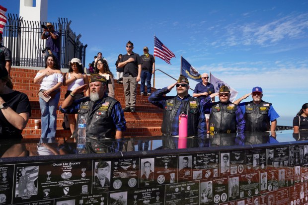 SAN DIEGO, CA - FEBRUARY 28: Members of VFW Riders Post 5867 in Lakeside, salute during the National Anthem, during the veteran honor ceremony and plaque presentation at Mt. Soledad National Veterans Memorial in La Jolla, Saturday, February 28, 2026, in San Diego, California, for Army nurse, Captain Jennifer Moreno, a San Diego High School graduate, killed in 2013, while supporting combat operations when providing medical assistance to wounded soldiers in Afghanistan. (Howard Lipin / For The San Diego Union-Tribune)
