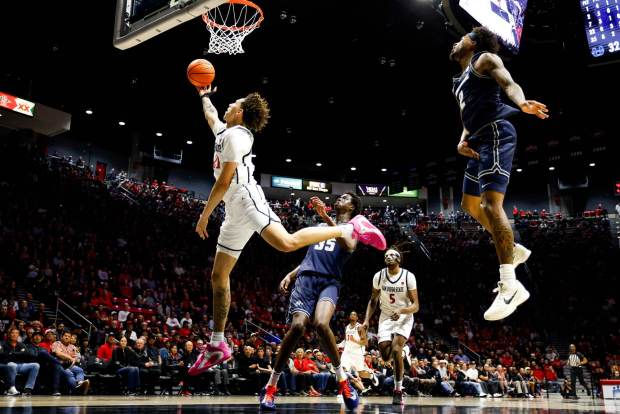 Miles Byrd #21 of San Diego State goes up for a shot against Adlan Elamin #35 of Utah State during their game at Viejas Arena on Wednesday, Feb. 25, 2026 in San Diego, California. (Meg McLaughlin / The San Diego Union-Tribune)