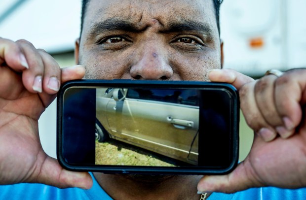 Herman Rovelo, 41, with a photo of his bullet-riddled car after a Honduran gang tried to kill him over 10 years ago. Rovelo said he had to get his family out of the country for their safety. The gang killed his brother and cousin. ICE arrested Rovelo in early January; he is now home with his family in San Jacinto on Wednesday, Feb. 25, 2026, after spending more than a month at Otay Mesa detention center until a judge ordered him released after his attorney filed a habeas corpus petition. (Photo by Terry Pierson, The Press-Enterprise/SCNG)