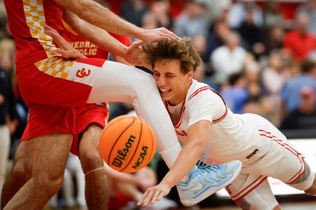 Santa Fe Christian's Dax Hall (1) falls on Cathedral Catholic's Kai Carlson (1) during the CIF San Diego Section Open Division boys basketball quarterfinal game at Santa Fe Christian School on Friday, Feb. 20, 2026 in Solana Beach, California. (Meg McLaughlin / The San Diego Union-Tribune)